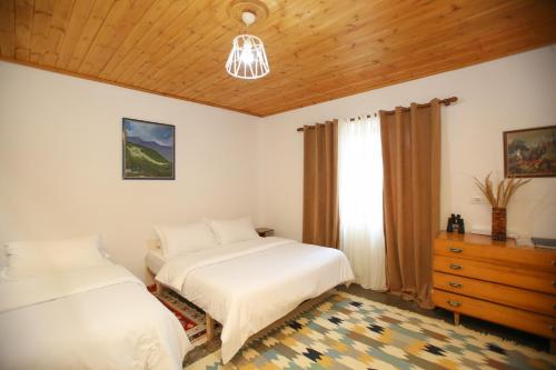 a bedroom with two beds and a dresser and a window at Guest House Bashaj in Bashaj