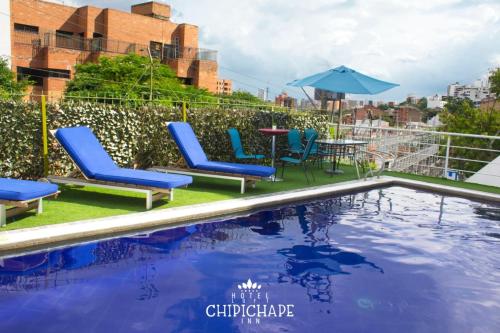 a pool with chairs and a table and an umbrella at CHIPICHAPE INN in Cali