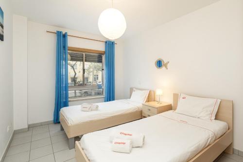 Dos camas en una habitación con ventana. en NEW - Portimao Casinha, en Praia da Rocha