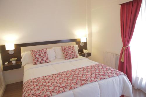 a bedroom with a large bed with red pillows at Pampa Plaza Hotel in Buenos Aires