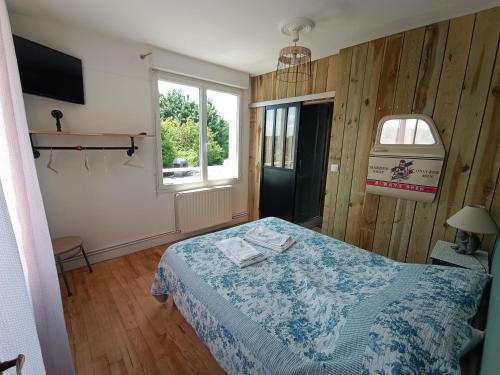 - une petite chambre avec un lit et une fenêtre dans l'établissement La cocotte normande, à Coudeville-sur-Mer