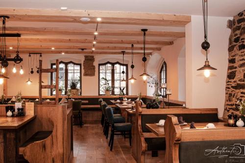 a restaurant with wooden tables and chairs and windows at Altstadt-Hotel in Freiberg