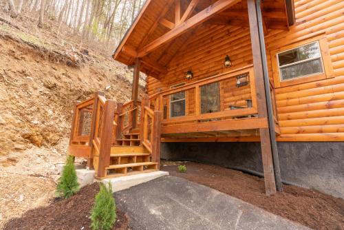 a cabin with a staircase leading to the front door at Hawks Nest Mountain Cabin in Sevierville