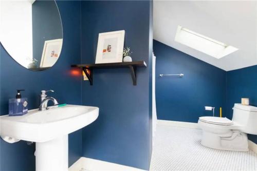 a blue bathroom with a sink and a toilet at Middletown Bungalow - RIBryan Property in Middletown