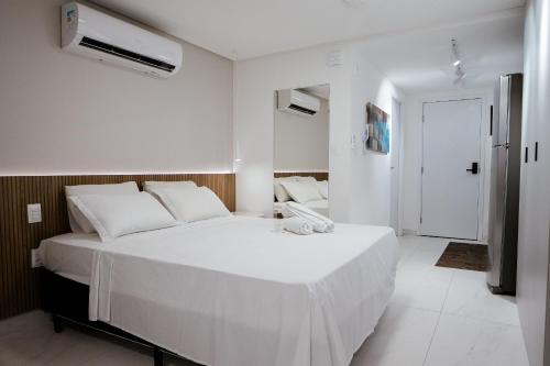 Un dormitorio blanco con una gran cama blanca. en Unity - Cabo Branco, en João Pessoa