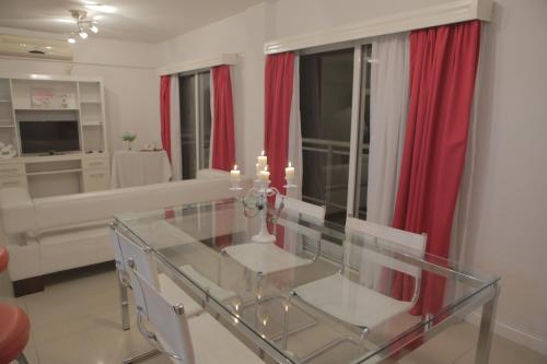 a dining room with a glass table and red curtains at Pampa Plaza Hotel in Buenos Aires
