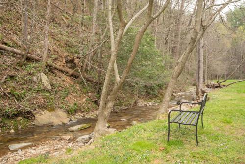a bench sitting in the grass next to a stream at Brand New Cabin in the Smokies in Sevierville