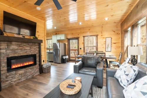 a living room with a fireplace in a log cabin at Brand New Cabin in the Smokies in Sevierville