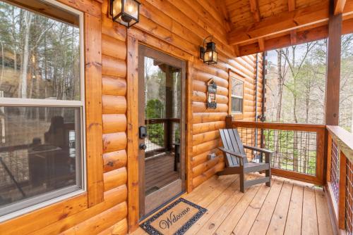 a rocking chair on the front porch of a log cabin at Hawks Nest Mountain Cabin in Sevierville