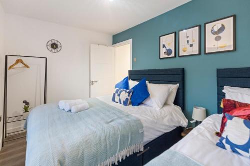 um quarto com 2 camas e paredes azuis em Diamond Suite Camden Town 3 Bedroom Sleeps 11 em Londres