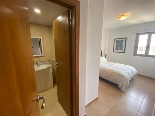 Un baño con un dormitorio con una cama y un lavabo. en Atico en Almadraba, en Benicàssim