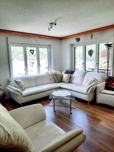 a living room with white couches and windows at Bodmen 3 Apartments von Privat in Zermatt in Zermatt