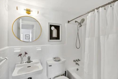 a white bathroom with a sink and a mirror at Crystal City Boutique Flats 2BR - Free Parking 2878 in Arlington