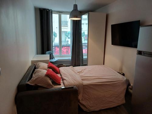 um quarto com uma cama, um sofá e uma janela em STUDIO CHARONNE em Paris