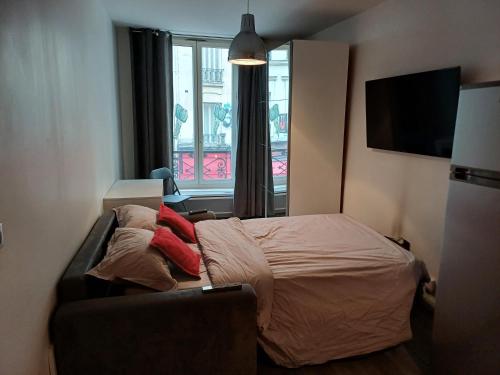 une chambre avec un lit, un canapé et une fenêtre dans l'établissement STUDIO CHARONNE, à Paris