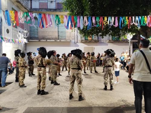 a group of soldiers in uniforms standing in a street at La camera nel villaggio in Messina