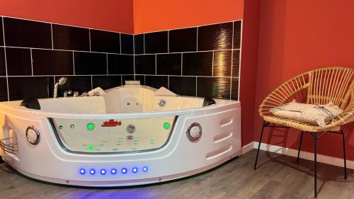 a bath tub in a room with two chairs at Balnéo Blanche Porte - Arrivée autonome in Tourcoing