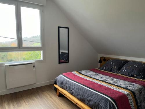 une chambre avec un lit et une grande fenêtre dans l'établissement Maison entre terre et mer, à Dinéault