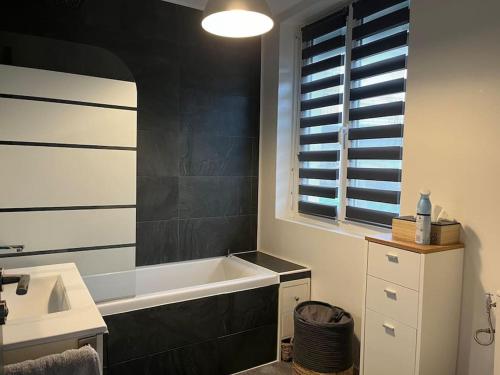 une salle de bain avec une baignoire et un lavabo dans l'établissement Maison entre terre et mer, à Dinéault