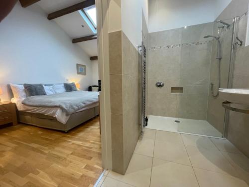 a bathroom with a bed and a shower and a sink at Lockgate Dairy in Chichester