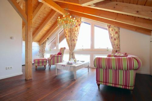 ein Wohnzimmer mit 2 Stühlen, einem Tisch und einem Kronleuchter in der Unterkunft Tolle Wohnung in Breitenau mit Kleinem Garten in Garmisch-Partenkirchen