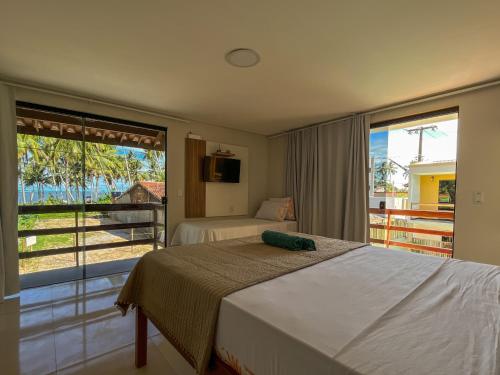 Habitación de hotel con 2 camas y balcón en Vila Hayô en Passo de Camarajibe