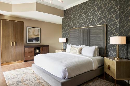 a bedroom with a large bed and a wall at The Chateau Grande Hotel in East Brunswick