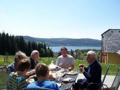 Eine Gruppe von Menschen, die an einem Tisch sitzen und essen in der Unterkunft Ferienhaus für 8 Personen ca 200 qm in Slupecna, Böhmen Moldau in Lipno nad Vltavou