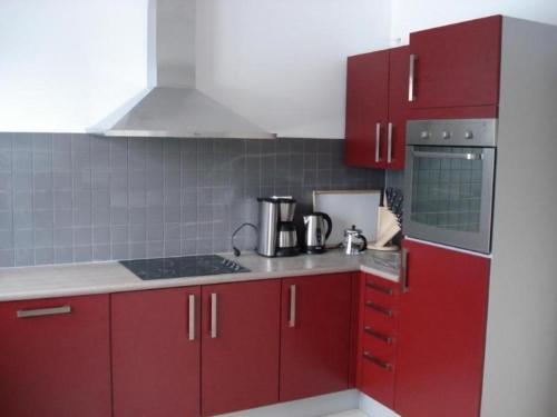 eine Küche mit roten Schränken und einem Herd in der Unterkunft Ferienhaus für 8 Personen ca 200 qm in Slupecna, Böhmen Moldau in Lipno nad Vltavou