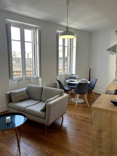 un salon avec un canapé et une table dans l'établissement Le Toulousain 302 - Appartement Cosy en Hypercentre - Quartier Jeanne-d'Arc, à Toulouse