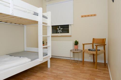 ein Schlafzimmer mit Etagenbetten und einem Stuhl in der Unterkunft Britz Hostel in Kristinehamn