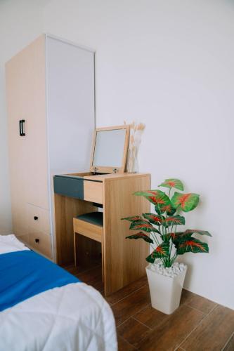a bedroom with a desk with a computer and a potted plant at Thuyền Xưa Homestay Đảo Phú Quý in Cu Lao Thu