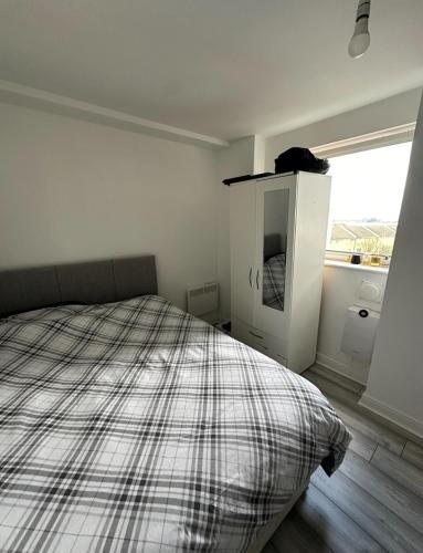 a white bedroom with a bed and a window at Room in a Shared Flat, E16 in London
