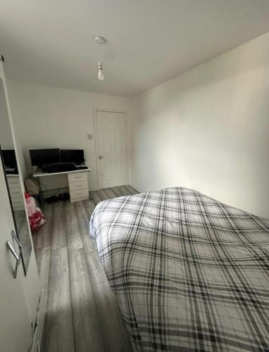 a white bedroom with a bed and a desk at Room in a Shared Flat, E16 in London