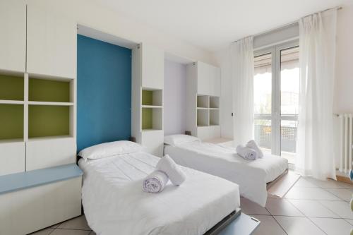 two beds in a room with white and blue at [Niguarda] - Ampio e Moderno Trilocale in Milan