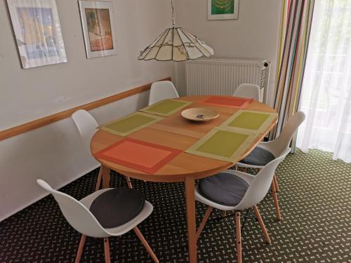 a dining room table with chairs and a colorful table at Rosa Canina, W5 in Kellenhusen