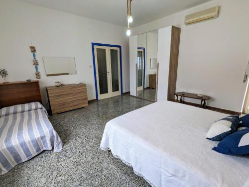 a bedroom with a large white bed and a mirror at Villa Mariuccia in Nebida