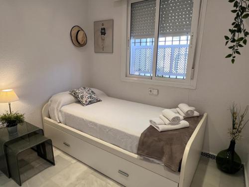 a small bedroom with a bed and a window at Apartamento Empul Costa Sancti Petri in Chiclana de la Frontera