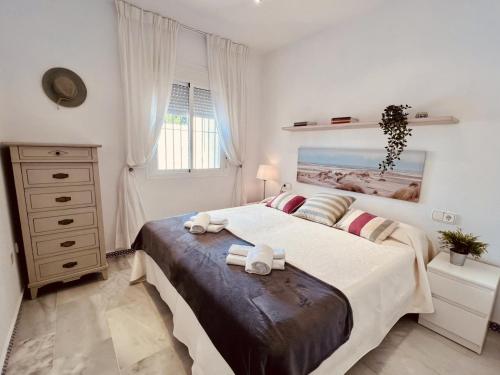 a bedroom with a large bed with towels on it at Apartamento Empul Costa Sancti Petri in Chiclana de la Frontera