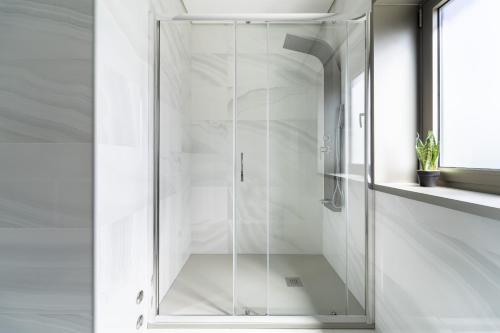 uma porta de duche em vidro numa casa de banho branca em Casa Eido Doce by House and People em Barcelos