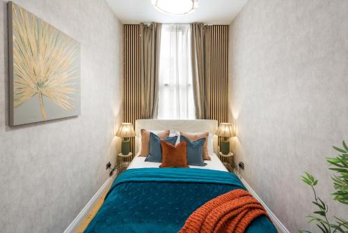 a bedroom with a bed with blue and orange pillows at Charming 1-Bed Apartment in London in London