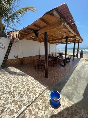 un pabellón con mesa y sillas en la playa en HABITACION FRENTE AL MAR, en Lobitos