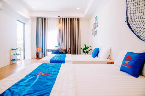 a hotel room with two beds and a table at Thuyền Xưa Homestay Đảo Phú Quý in Cu Lao Thu