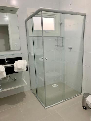 een glazen douche in een badkamer met een wastafel bij Pousada Maratá in Maratá