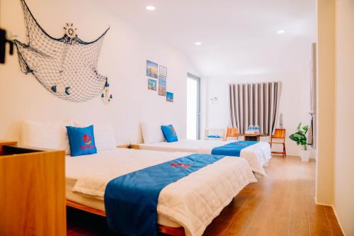 a bedroom with two beds with blue and white sheets at Thuyền Xưa Homestay Đảo Phú Quý in Cu Lao Thu