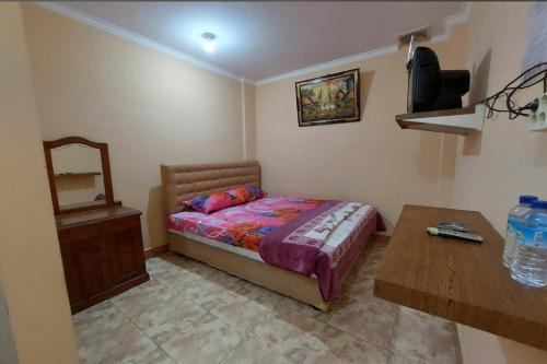 um pequeno quarto com uma cama e uma mesa em OYO 93757 Rasya Homestay em Midang