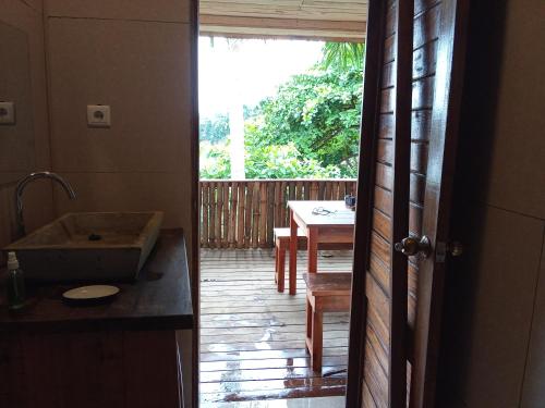 SantʼAnaにあるInfinity-house with direct access to the beachのテーブルとダイニングルーム付きのキッチンへ続くオープンドア