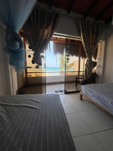 1 dormitorio con cama y vistas al océano en HABITACION FRENTE AL MAR, en Lobitos