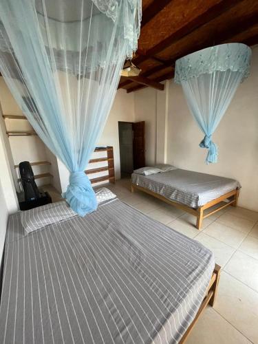 1 dormitorio con 2 camas y cortinas azules en HABITACION FRENTE AL MAR, en Lobitos
