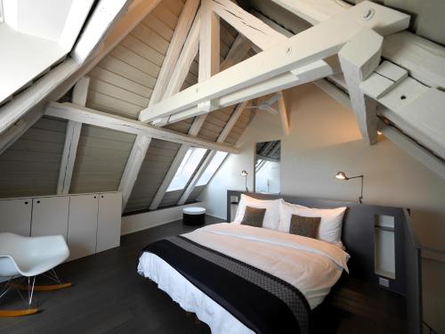 ein Schlafzimmer mit einem großen Bett im Loft in der Unterkunft L'Eau Forte - maison d'hôtes in Saint-Blaise